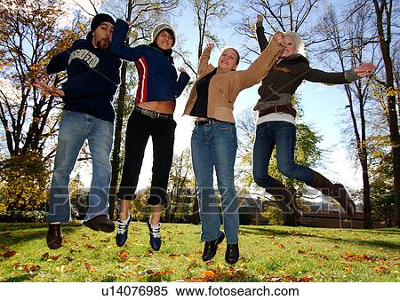 Four ecstatic friends in midair in a park. View Large Photo Image Stock Photography - Four ecstatic friends in midair in a park.. Fotosearch