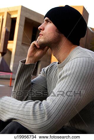Portrait of a young man conversing on his cell phone. View Large Photo Image Picture - Portrait of a young man conversing on his cell phone.. Fotosearch