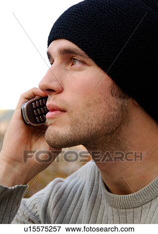Portrait of a young man conversing on his cell phone. View Large Photo Image Stock Photo - Portrait of a young man conversing on his cell phone.. Fotosearch