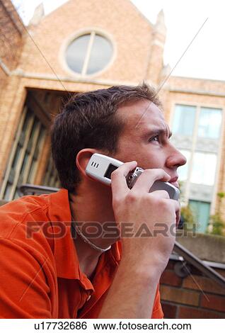 Portrait of a young man conversing on his cell phone. View Large Photo Image Stock Photograph - Portrait of a young man conversing on his cell phone.. Fotosearch