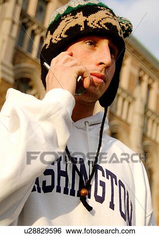 Portrait of a young man conversing on his cell phone. View Large Photo Image Stock Photograph - Portrait of a young man conversing on his cell phone.. Fotosearch