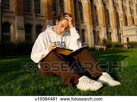 View of a young man engrossed in a book. View Large Photo Image Stock Image - View of a young man engrossed in a book.. Fotosearch