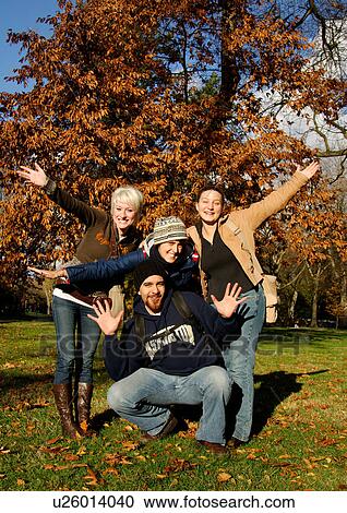 Stock Image - View of four friends posing for the camera.. Fotosearch