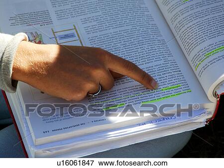A student is pointing at a highlighted line in a book. View Large Photo Image Stock Photo - A student is pointing at a highlighted line in a book.. Fotosearch
