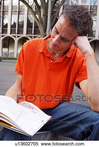 Stock Photography - A young man reading a book.. Fotosearch