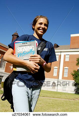 Portrait of a cheerful young woman holding her books. View Large Photo Image Stock Image - Portrait of a cheerful young woman holding her books.. Fotosearch