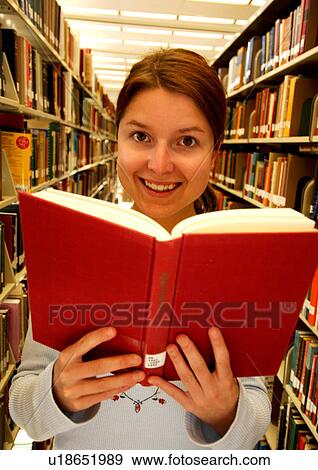 Portrait of a young woman reading a book in a library. View Large Photo Image Stock Photo - Portrait of a young woman reading a book in a library.. Fotosearch