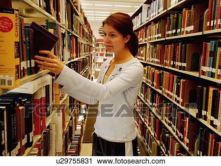 Profile of a young woman picking a book from a library. View Large Photo Image Stock Image - Profile of a young woman picking a book from a library.. Fotosearch