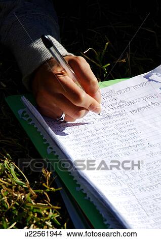 View of a person writing on a book. View Large Photo Image Picture - View of a person writing on a book.. Fotosearch