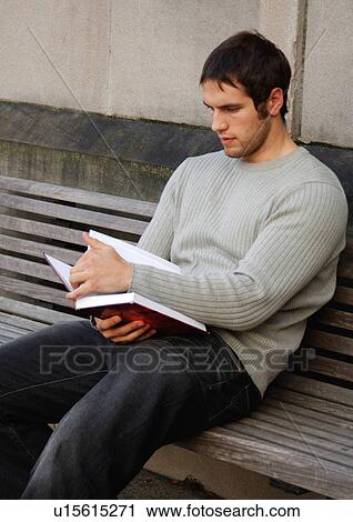 View of a young man engrossed in a book. View Large Photo Image Stock Image - View of a young man engrossed in a book.. Fotosearch