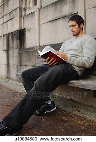 View of a young man engrossed in a book. View Large Photo Image Stock Image - View of a young man engrossed in a book.. Fotosearch