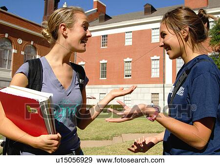 View of two young women engaged in a conversation. View Large Photo Image Stock Photo - View of two young women engaged in a conversation.. Fotosearch
