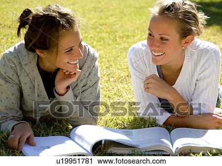 View of two young women reading books on a lawn. View Large Photo Image Stock Image - View of two young women reading books on a lawn.. Fotosearch