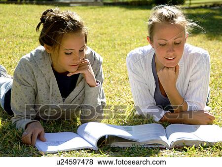 View of two young women studying on a lawn. View Large Photo Image Stock Photo - View of two young women studying on a lawn.. Fotosearch