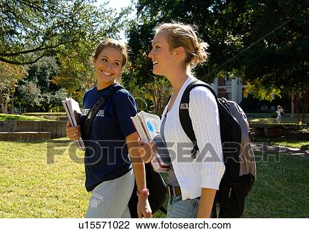 View of two young women walking on the lawn. View Large Photo Image Stock Image - View of two young women walking on the lawn.. Fotosearch