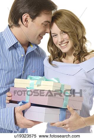 A couple holds boxes of gifts. View Large Photo Image Stock Photography - A couple holds boxes of gifts.. Fotosearch