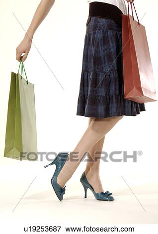 Cropped view of a woman holding shopping bags. View Large Photo Image Stock Photo - Cropped view of a woman holding shopping bags.. Fotosearch