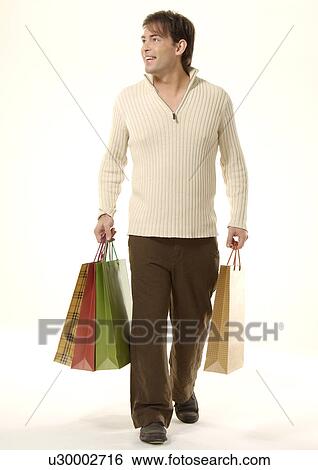 Front view of a young man carrying shopping bags. View Large Photo Image Stock Photograph - Front view of a young man carrying shopping bags.. Fotosearch