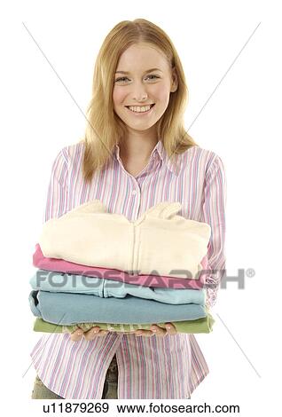 Stock Photo - Portrait of a cheerful woman holding folded apparels.. Fotosearch