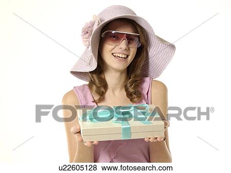 Stock Photo - Portrait of a fashionable woman holding a gift packet.. Fotosearch