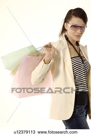 Portrait of a trendy young woman carrying shopping bags. View Large Photo Image Stock Image - Portrait of a trendy young woman carrying shopping bags.. Fotosearch