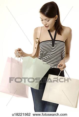 Portrait of a trendy young woman carrying shopping bags. View Large Photo Image Stock Image - Portrait of a trendy young woman carrying shopping bags.. Fotosearch