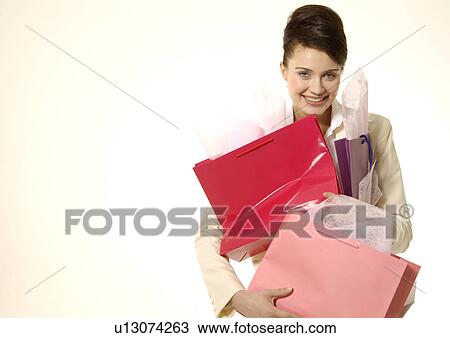 Stock Image - Portrait of a woman with shopping bags.. Fotosearch