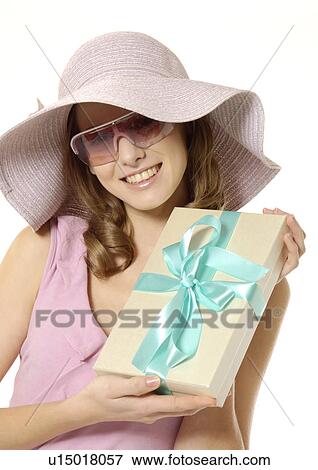 Portrait of a young woman displaying a gift wrapped in ribbon. View Large Photo Image Stock Photo - Portrait of a young woman displaying a gift wrapped in ribbon.. Fotosearch