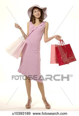Stock Photo - Portrait of a young woman posing with her shopping bags.. Fotosearch