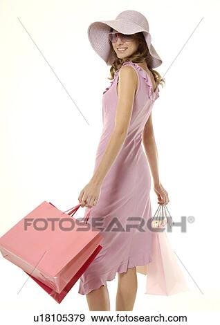 Stock Photo - Portrait of a young woman posing with her shopping bags.. Fotosearch