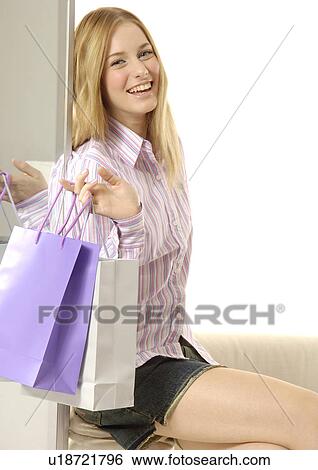 Side view of a charming woman holding her shopping bags. View Large Photo Image Stock Photograph - Side view of a charming woman holding her shopping bags.. Fotosearch