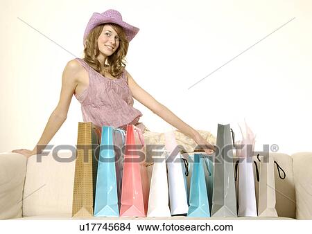Picture - View of a charming woman posing with her carrier bags.. Fotosearch