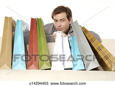 View of a young man posing with his carrier bags. View Large Photo Image Stock Image - View of a young man posing with his carrier bags.. Fotosearch