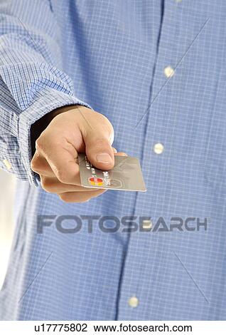 Stock Image - Cropped view of a man holding a credit card.. Fotosearch