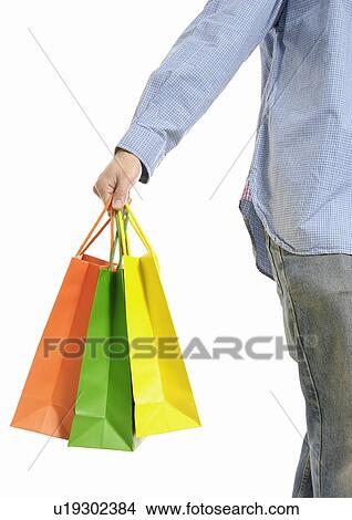 Cropped view of a man holding shopping bags. View Large Photo Image Picture - Cropped view of a man holding shopping bags.. Fotosearch
