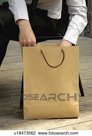 Cropped view of a man opening a carrier bag. View Large Photo Image Stock Image - Cropped view of a man opening a carrier bag.. Fotosearch