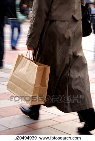 Cropped view of a woman holding a carrier bag. View Large Photo Image Stock Photo - Cropped view of a woman holding a carrier bag.. Fotosearch