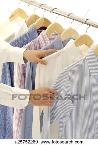 Cropped view of a woman selecting a shirt. View Large Photo Image Stock Photo - Cropped view of a woman selecting a shirt.. Fotosearch
