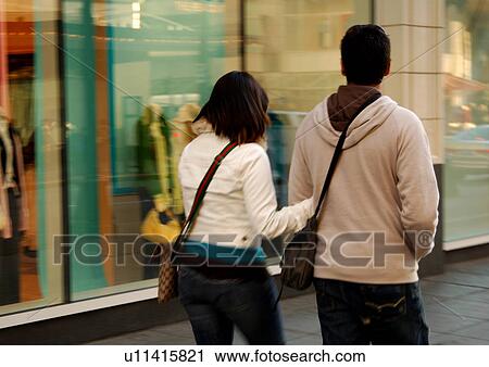 View of a couple walking past shops. View Large Photo Image Stock Image - View of a couple walking past shops.. Fotosearch