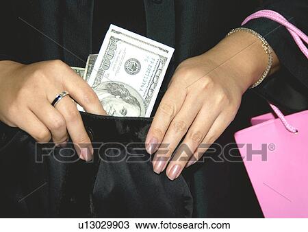 View of a woman holding a purse filled with money. View Large Photo Image Stock Image - View of a woman holding a purse filled with money.. Fotosearch