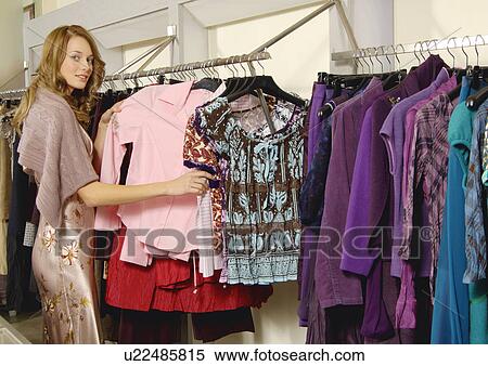 View of a young woman shopping in a store. View Large Photo Image Stock Photography - View of a young woman shopping in a store.. Fotosearch