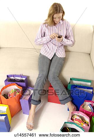 View of a young woman with colorful shopping bags placed in front of her. View Large Photo Image Stock Image - View of a young woman with colorful shopping bags placed in front of her.. Fotosearch