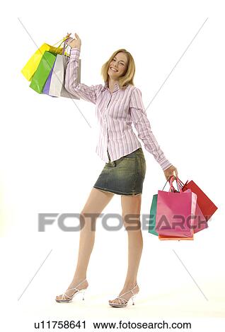 Stock Image - View of an attractive woman holding shopping bags.. Fotosearch