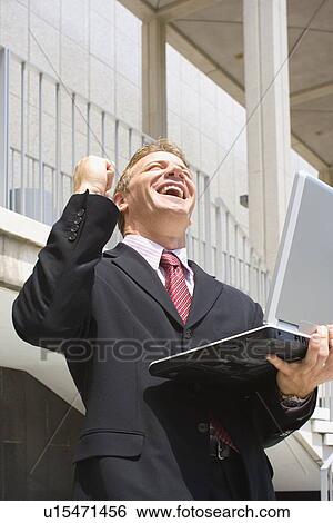 A Mid Adult Businessman Clenching a Fist and Smiling, Low Angle View, Waist Up, Front View View Large Photo Image Stock Photograph - A Mid Adult Businessman Clenching a Fist and Smiling, Low Angle View, Waist Up, Front View. Fotosearch