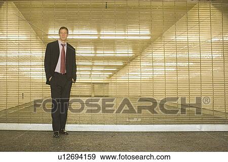 A Mid Adult Businessman Standing on a Shuttered Corridor, Front View, Full Length View Large Photo Image Stock Photo - A Mid Adult Businessman Standing on a Shuttered Corridor, Front View, Full Length. Fotosearch