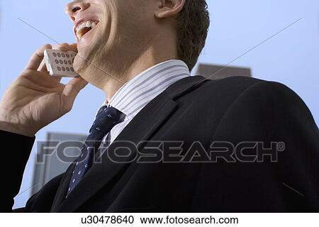 A Mid Adult Businessman Talking on the Cellular Phone, Low Angle View, Close Up, Head And Shoulders View Large Photo Image Stock Image - A Mid Adult Businessman Talking on the Cellular Phone, Low Angle View, Close Up, Head And Shoulders. Fotosearch