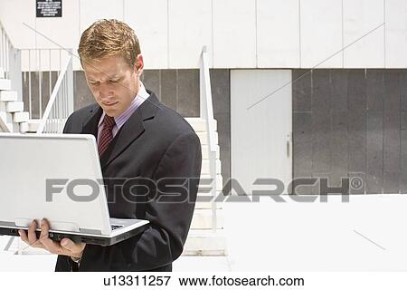 A Mid Adult Businessman Using a Notebook Computer, Waist Up View Large Photo Image Stock Photo - A Mid Adult Businessman Using a Notebook Computer, Waist Up. Fotosearch