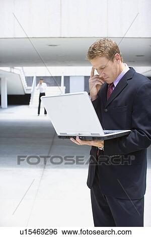 A Mid Adult Businessman Using a Notebook Computer, Waist Up View Large Photo Image Stock Photograph - A Mid Adult Businessman Using a Notebook Computer, Waist Up. Fotosearch