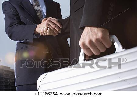 Picture - A Pair of Businessman Shaking Hands, Close Up, Lens Flare. Fotosearch