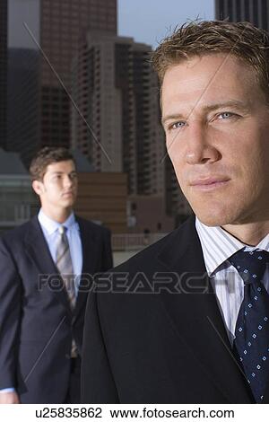 Stock Image - A Pair of Businessman Standing in the Downtown, Front View, Head and Shoulders, Waist Up. Fotosearch